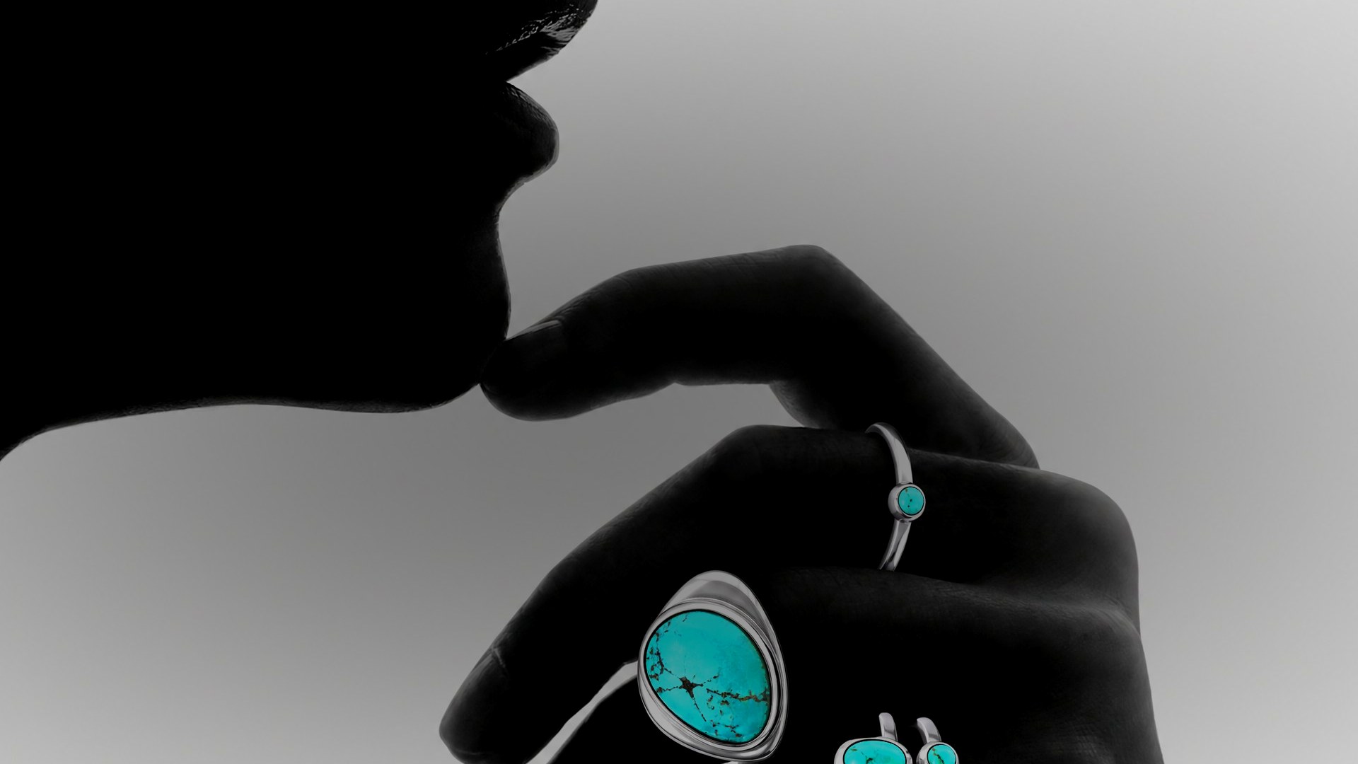 Hand wearing TCHIRU silver rings set with turquoise — Silver, Stone, Skin.